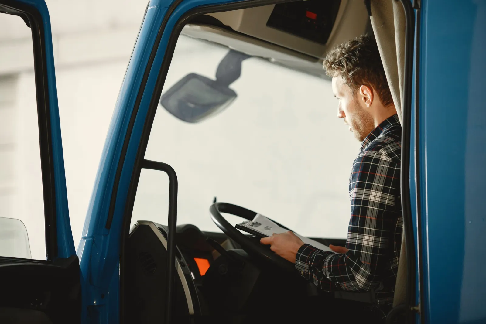 A driver going over his paperwork in the cab